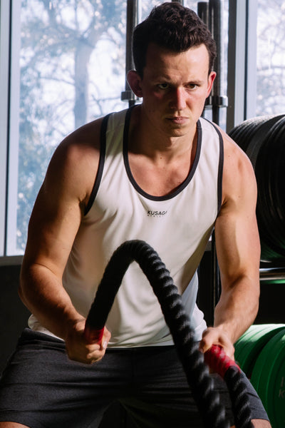 Male body builder wearing a white ECODRY® racerback from Kusaga Athletic